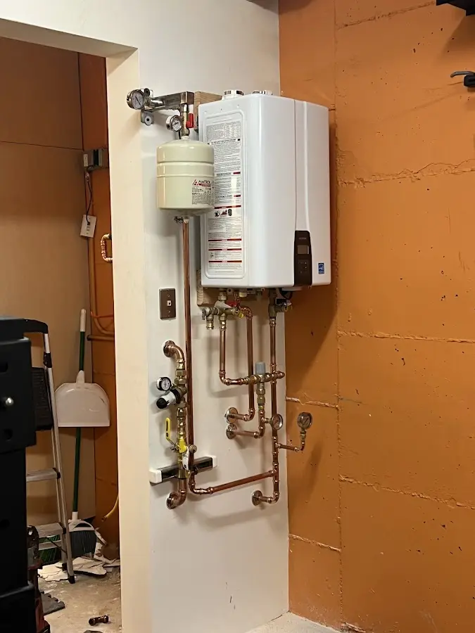 Plumbing technician inspecting water heater connections in Trophy Club